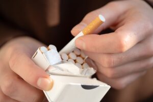a person holds a pack of cigarettes